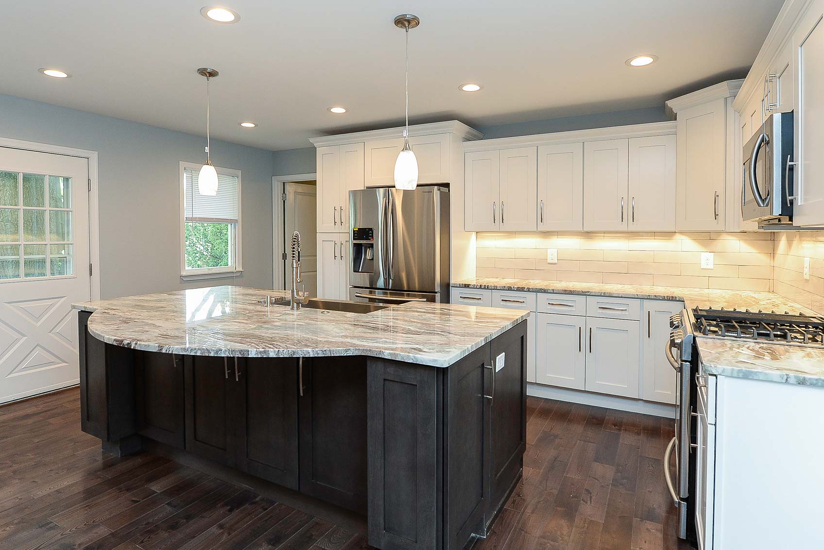 Picture of kitchen with an island and white lamps, designed by Goldleaf Designs