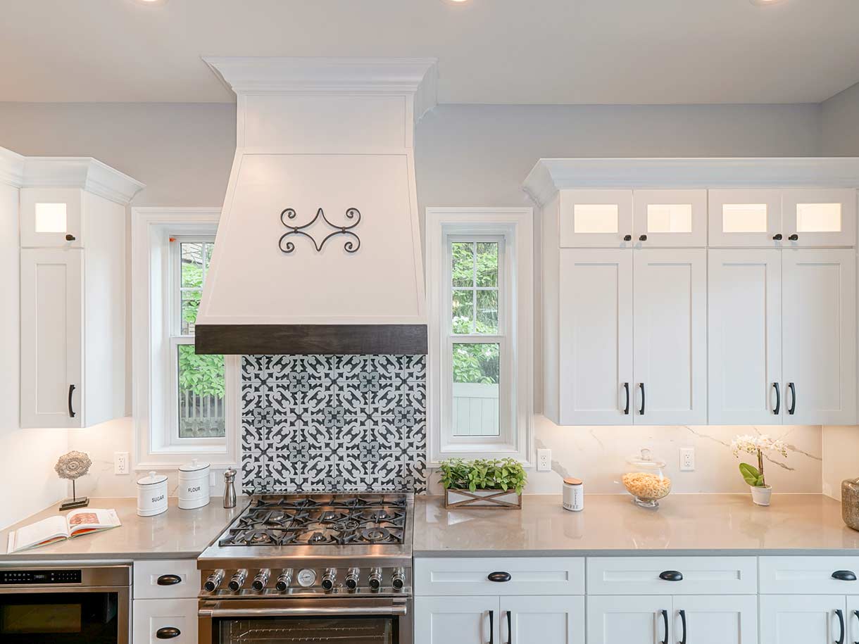Counter in kitchen with designed backsplash tiles and under cabinet lighting