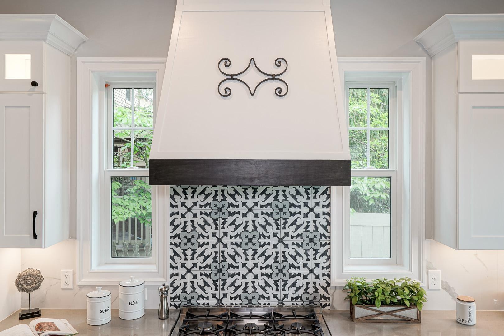 Counter in kitchen with designed backsplash tiles and under cabinet lighting